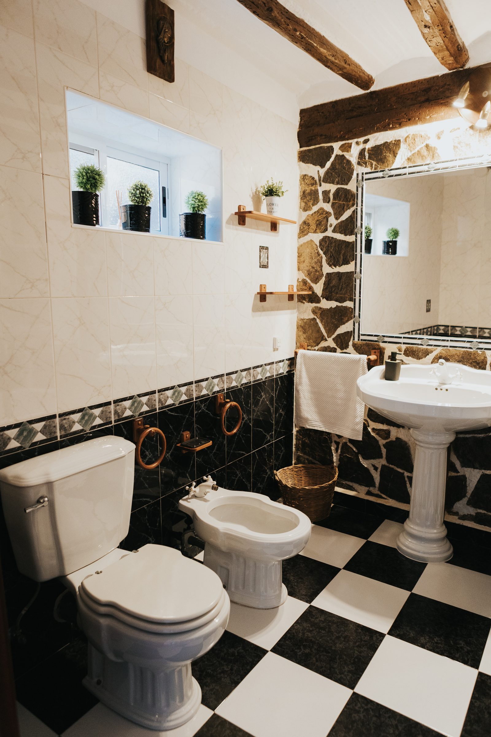 Baño rústico con pared de piedra